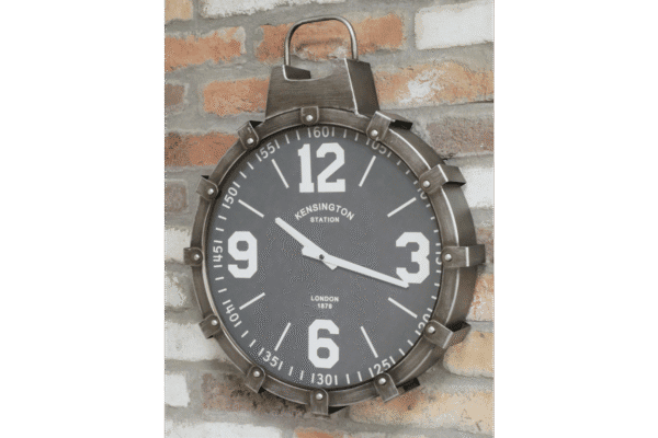 Industrial cog style clock with black face and white numerals, mounted on a brick wall, featuring a vintage design from Stringers Home Decorating Centre.