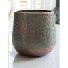 Close-up of a textured aluminium pitted planter with a weathered finish, suitable for outdoor or indoor garden decor.