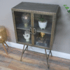 Industrial display cabinet with two glass shelves and metal frame, ideal for home decor and showcasing collectibles.