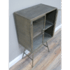 Industrial display cabinet with two glass shelves and metal frame, ideal for showcasing items in a modern home or retail setting.