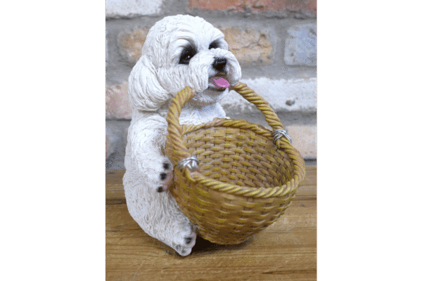 Cute ceramic dog figurine holding a woven basket with a brick wall background.