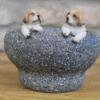 Decorative small dog figurines in a stone trough for home decor or gardening.