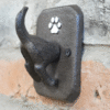 Dog coat hook mounted on a brick wall, featuring a paw print design for pet accessories storage.
