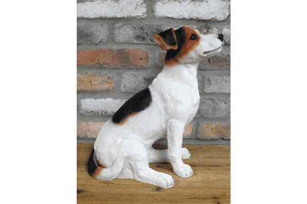 Sitting Jack Russell dog figurine against a brick wall, showcasing its white coat with black and brown markings.