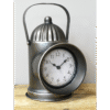 Vintage railway-inspired metal clock with lantern design, featuring a round white dial and black numerals, on a wooden surface.