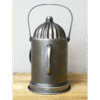 Vintage metal lantern with a domed top and handle, placed on a wooden surface, suitable for railway or industrial decor.