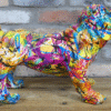 Colourful graffiti-style dog sculpture with vibrant paint splashes on a wooden surface against a brick wall.