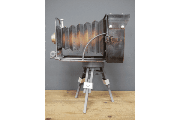 Vintage camera clock designed to resemble an old-fashioned camera, with a bellows-style body and tripod stand, perfect for vintage decor enthusiasts.