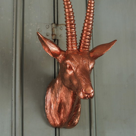 Decorative copper-coloured mounted antelope head sculpture with detailed features and textured surface.