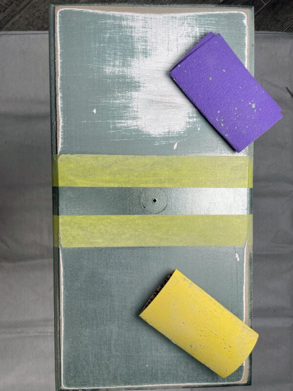 Stringers DIY sanding blocks in purple and yellow on a sanding board for home decorating projects.