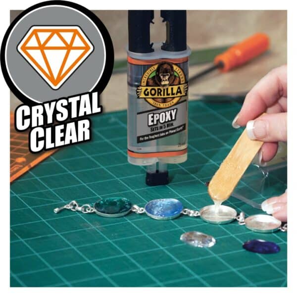 Applying Gorilla Epoxy Glue to a jewelry piece on a green cutting mat with tools in the background.