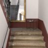 Interior stone staircase with decorative railing and mirror, showcasing home decor and flooring details.