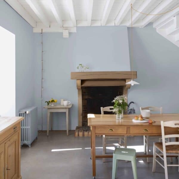 Bright and airy dining room with wooden furniture, a fireplace, and natural light from a window, showcasing home decorating ideas.