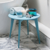 Bathroom side table with towel, candles, and decorative items in a modern bathroom setting.