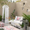 Stylish outdoor patio with beige walls, lush green plants, and comfortable seating for relaxing or entertaining.