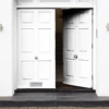 Modern white double garage doors with a partially open door revealing a staircase inside.