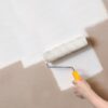 Ronseal 3 in 1 Basecoat being applied to a bare plaster wall using a roller with yellow handle showing coverage in one coat