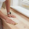 Person sanding wooden surface using Fit For The Job sandpaper sheet