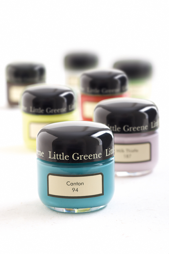 Little Greene 60ml colour sample pots in various shades, including blue, yellow, red, and purple, displayed on a white background.
